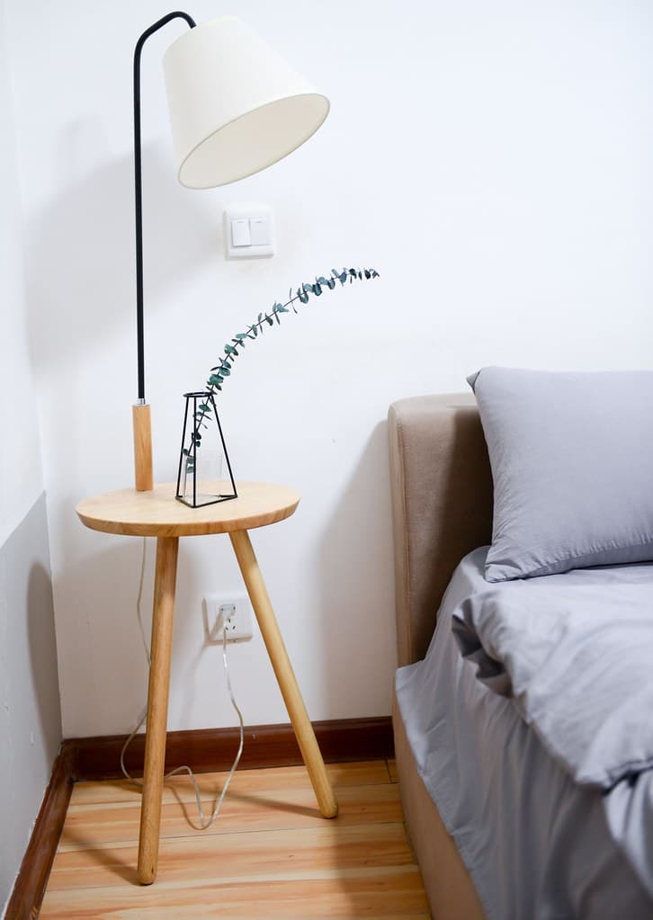 White shade table lamp near bed