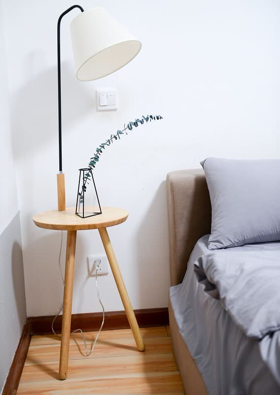 White shade table lamp near bed