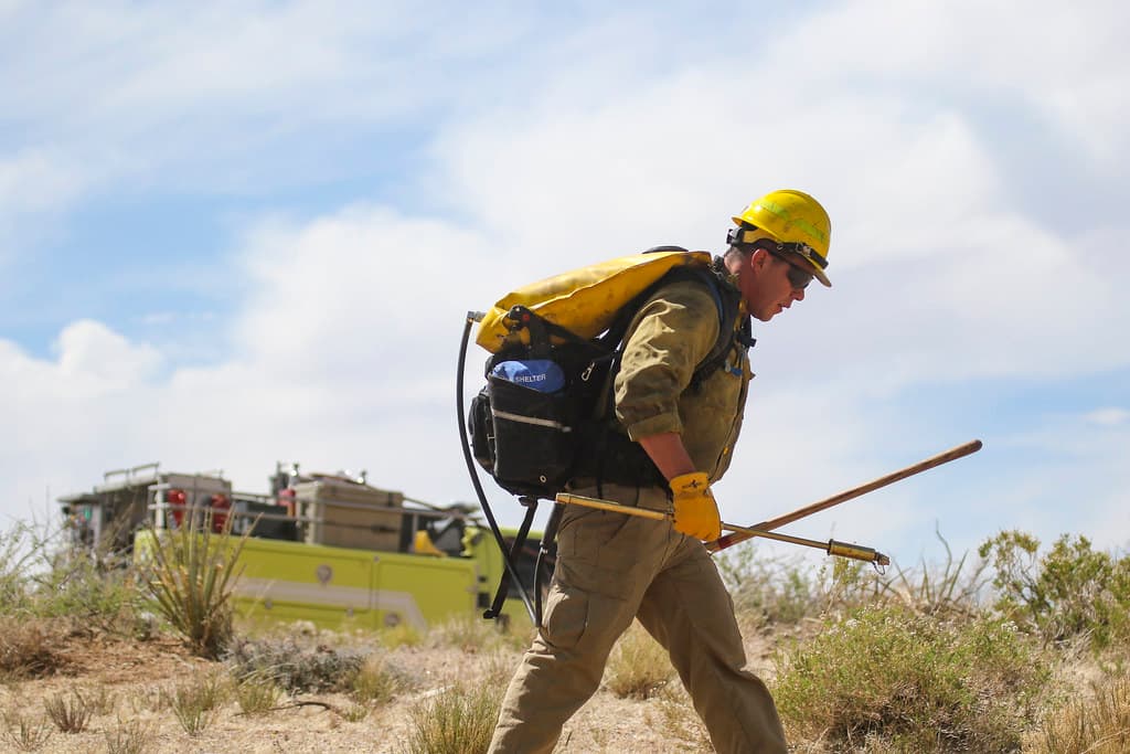 MAY 15: Firefighter with backpack fire pump and tools