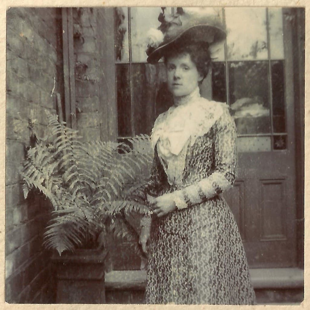 Unknown lady, lovely dress, hat and fern!