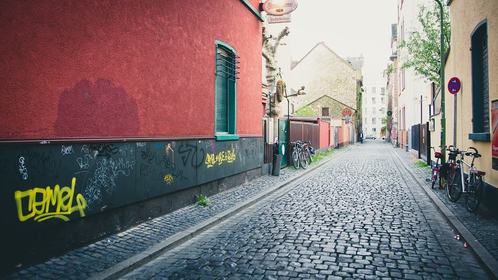 Graffiti on Wall Near Cobbled Street