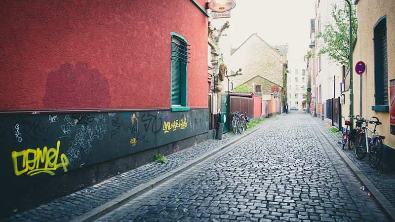 Graffiti on Wall Near Cobbled Street