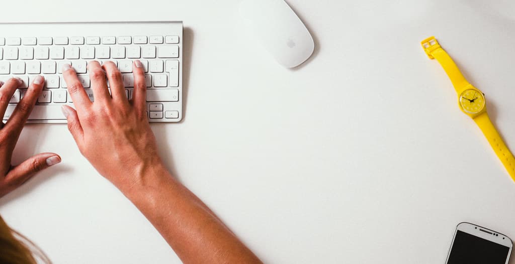 Hands Typing on Keyboard with Apple Mouse and Yellow Watch