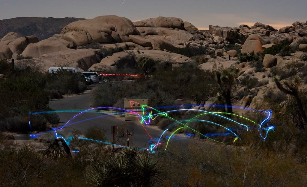 Campers toss a light-up disc back and forth in Jumbo Rocks Campground