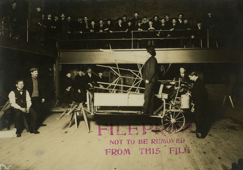 A Professor is Showing and Teaching a Class About a Piece of Machinery