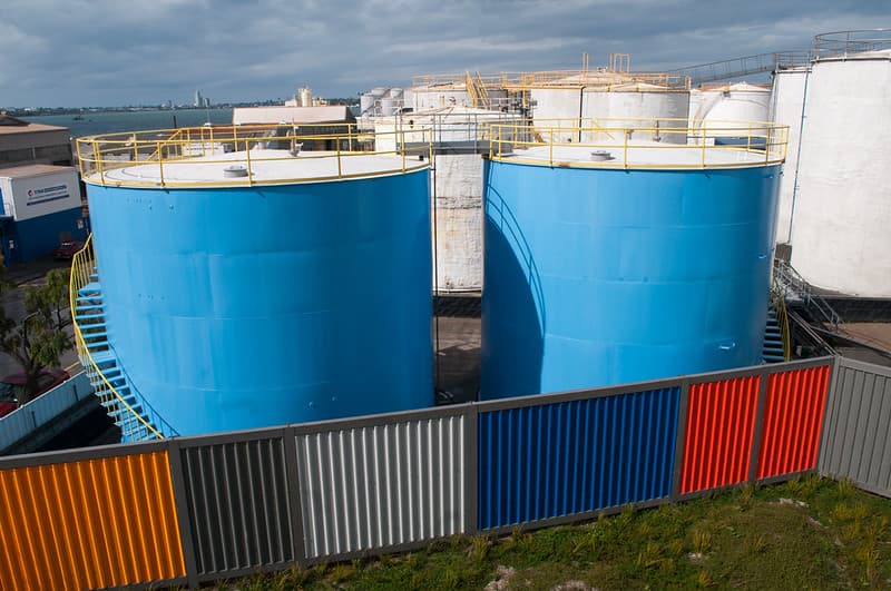 Industrial silos behind multicolored fence in Silo Park, Auckland
