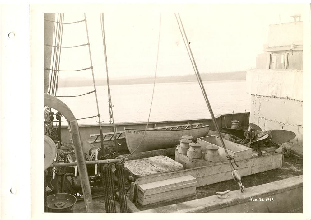 View of deck of boat being equipped, note lifeboat and propeller