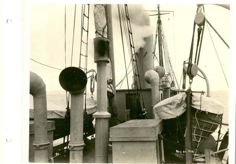 View of lifeboat and various stacks on aft deck of boat being equipped