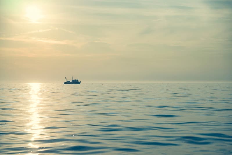 Fishing Boat in Ocean at Sunset