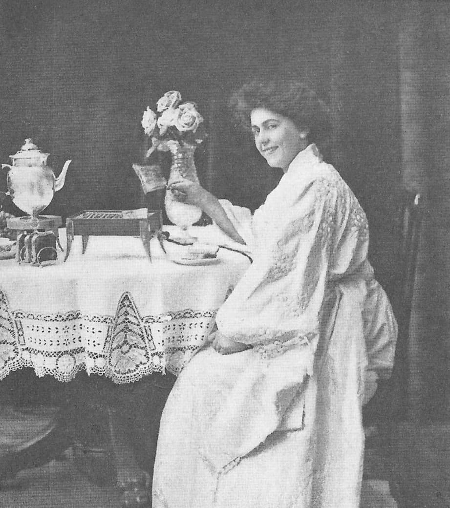 Woman using electric toaster circa 1905