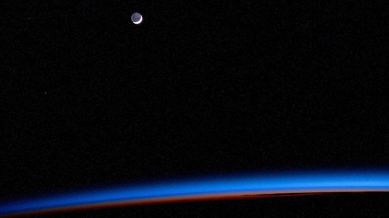The waning crescent Moon above Earth's horizon