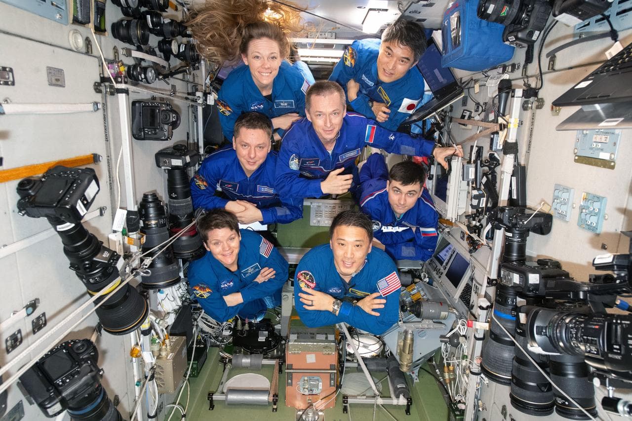 The seven-member Expedition 73 crew poses for a portrait