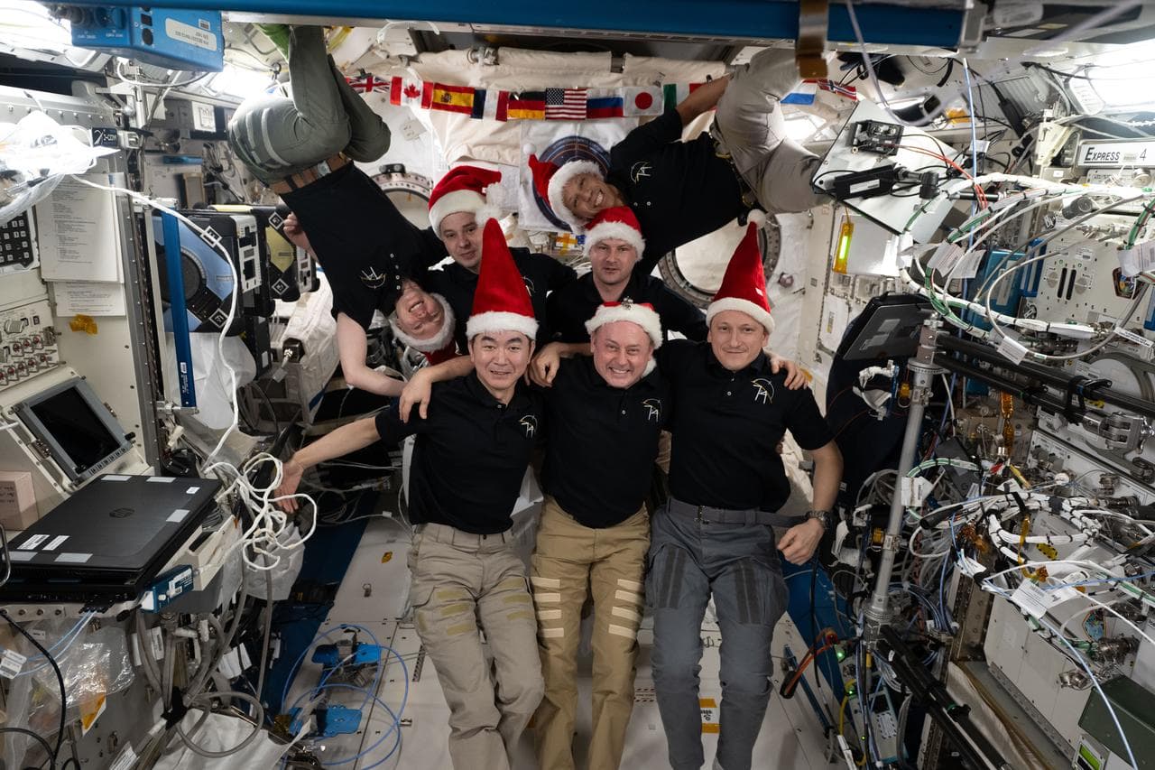 The seven-member Expedition 74 crew poses for a festive portrait