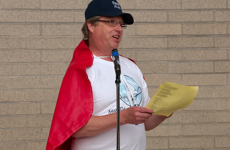 Man in red cape leading singing workshop 2