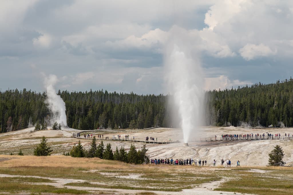 People watching Beehive Geyser erupt with Lion Geyser in the backgroup