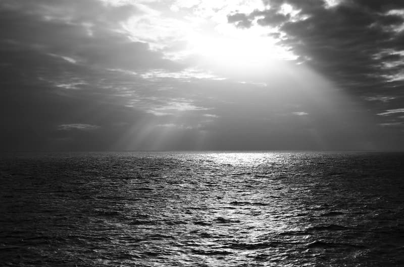 Sun Shining Through Clouds on Open Ocean Water