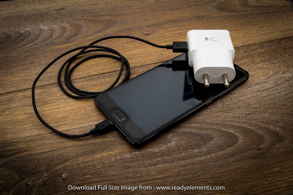 A black mobile phone battery charger with black usb cable
